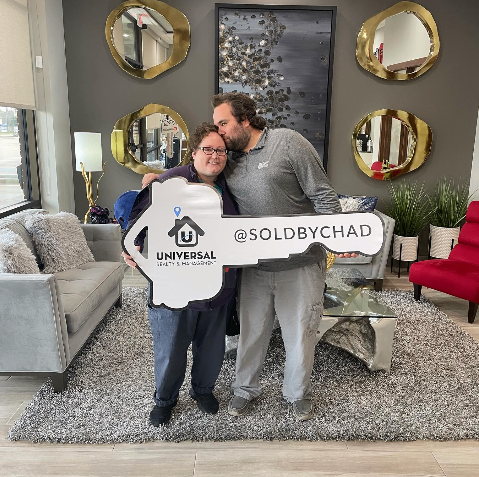 Happy couple with a Sold by Chad key at closing